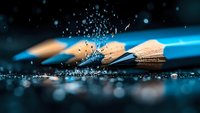 Dramatic macro shot of wooden and blue pencils with water droplets and splashes against dark background, creating artistic bokeh effect and dynamic composition.