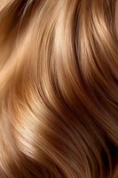 Close-up of flowing honey blonde hair with natural waves showing smooth, glossy texture and highlights for beauty and haircare advertising.