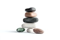 Balanced stack of natural zen stones in various colors and textures on white background, isolated spa and wellness composition for meditation and relaxation.