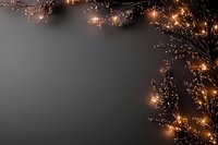 Glowing warm fairy lights and delicate branches create magical border frame on dark gray background, perfect for seasonal greeting cards and festive designs.