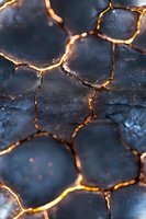 Glowing golden cracks on dark textured surface create dramatic pattern of illuminated fissures, abstract background for creative design projects.