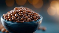 Fresh brown lentils in dark ceramic bowl against blurred bokeh background, macro food photography with selective focus and warm lighting effects.