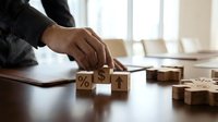 Business professional arranging wooden blocks with percentage and arrow symbols on desk for financial planning and growth strategy concepts.