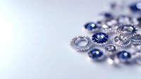 Metallic silver and blue gears scattered on light surface with selective focus creating depth effect. Engineering and mechanical concept background.