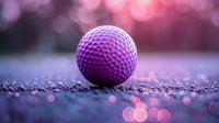 Purple golf ball on glittering surface with soft pink and purple bokeh lights creating dreamy atmospheric sports background for golf-related designs.
