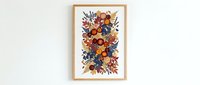 Autumn floral arrangement with orange and blue flowers in wooden frame hanging on white wall for seasonal home decor and interior design projects.