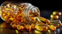 Golden omega-3 fish oil capsules spilling from glass bottle on dark background, showcasing nutritional supplements for health and wellness.