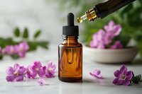 Amber glass dropper bottle with essential oil and pink orchid flowers on light background. Aromatherapy and natural wellness concept for spa and beauty.