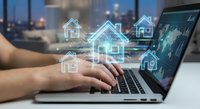 Professional using laptop with digital house icons floating above keyboard representing online real estate technology and property management solutions.