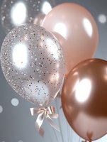 Elegant party balloons in rose gold and silver with glitter and satin bow against blurred bokeh background. Festive celebration decor for wedding or birthday.