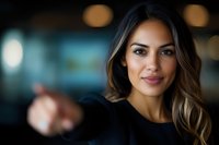 Young Hispanic businesswoman with confident smile and wavy highlighted hair against blurred office background, professional corporate portrait with bokeh lighting effect.