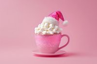 Pink glittery cup filled with mini marshmallows topped with sparkly santa hat on pink background, festive holiday drink concept for christmas season.