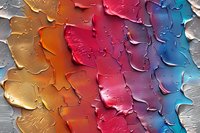 Colorful abstract paint texture with cracked surface effect showing vibrant gradient from gold through red to blue tones, featuring peeling and textured patterns.