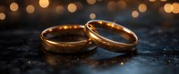 Golden wedding rings on dark textured surface with romantic bokeh lights in background, symbolizing marriage, commitment and eternal love. Macro jewelry photography.