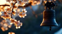 Bronze church bell silhouetted against evening sky with blooming cherry blossoms in warm sunset light creating atmospheric spring composition.