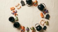 Colorful collection of miniature tea sets and figurines arranged in circular pattern on neutral background for crafting and dollhouse decoration projects.