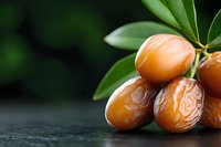 Fresh dates fruit with green leaves on dark surface, natural organic food ingredient for healthy eating and Middle Eastern cuisine recipes.