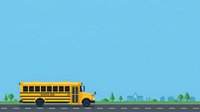 Yellow school bus traveling on road with green trees and buildings in background against blue sky.