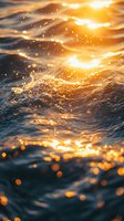 Magical ocean waves at golden sunset with sparkling water drops and bokeh light effects creating dreamy atmosphere for nature backgrounds and wallpapers.