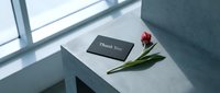 Black thank you card with red tulip on concrete surface in natural light, minimalist style for greeting, appreciation, and gratitude concepts.