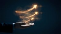 Businessman hand holding glowing upward arrows symbolizing growth, success and progress in dark background for business presentations and marketing.