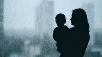 Mother holding child silhouette against rainy window with water drops, emotional bonding moment during storm weather for family concepts.