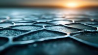 Macro photography of water droplets on dark geometric pattern surface with golden sunset light creating dramatic mood and depth of field effect.