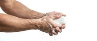 Male hands washing with soap and water droplets isolated on white background for hygiene and cleanliness concepts.