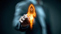 Glowing orange neon rocket icon launches from businessman's hand against dark background, symbolizing business startup and innovation concept.