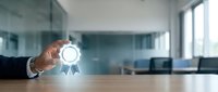 Business professional holding glowing award medal icon in modern office environment representing achievement, recognition and success in corporate workplace.