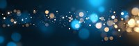Glowing blue and gold bokeh lights create magical sparkle effect against dark background, abstract festive panoramic design for holiday decorations and celebrations.