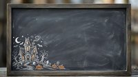 Haunted castle with pumpkins and moon drawn in chalk on blackboard with wooden frame, Halloween theme.