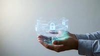 Business professional holding holographic cybersecurity interface with lock icons and data protection elements for digital security technology concepts.