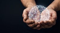 Male hands holding glowing digital network sphere with connected nodes on dark background for technology and innovation concepts.