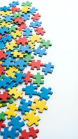 Colorful jigsaw puzzle pieces scattered on white background for teamwork, problem solving, autism awareness and educational concepts with copy space.
