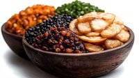 Wooden bowl filled with assorted legumes including black beans, lentils, chickpeas and sliced sausage for healthy protein meal preparation.