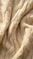 Cozy cream cable knit sweater fabric with intricate braided pattern and soft wool texture for fashion and comfort concepts.