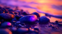 Wet pebbles on beach at sunset with vibrant purple and orange sky reflection creating magical atmosphere, stones glistening with water droplets.