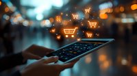 Online shopping concept with glowing shopping cart icons floating above digital tablet in dark environment with bokeh lights and hands typing.