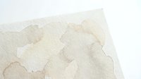 Abstract watercolor background with soft beige and cream tones creating organic flowing shapes on textured paper surface for artistic projects.