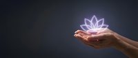 Hand holding glowing lotus flower with purple neon light against dark background, representing spirituality, wellness, meditation, and healing energy for wellness concepts.