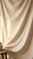 Soft beige fabric drape with natural lighting creates warm minimalist backdrop for product photography and interior design projects.