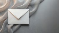 Elegant white envelope on soft beige silk fabric background for luxury correspondence, wedding invitations, business communications and stationery design.