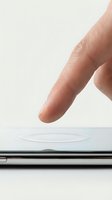 Finger touching smartphone screen with ripple effect, close-up macro shot on white background for technology and mobile concepts.