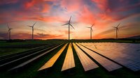 Wind turbines and solar panels in rural landscape at dramatic sunset, representing renewable energy and sustainable power generation for clean technology and environmental conservation projects.