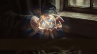 Hands cupped holding glowing orb of light with magical energy rays emanating outward in atmospheric indoor setting for spiritual and mystical concepts.