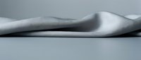 Artistic nude silhouette of woman lying on side in minimalist black and white photography with soft lighting and clean composition for wellness concepts.
