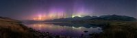 Panoramic view of colorful aurora borealis dancing over calm lake at night, reflecting in water with mountains silhouette and starry sky. Perfect for travel and nature themes.