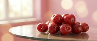 Fresh red cherries with water droplets on white plate in bright kitchen with soft bokeh lighting for healthy eating and summer fruit concepts.
