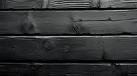Dark wooden planks with natural grain texture and knots create rustic horizontal lines in monochrome black background, suitable for design overlays.